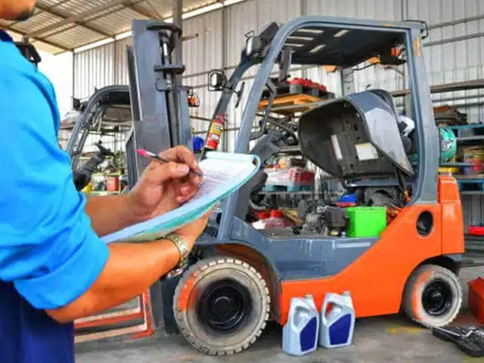 A technician inspecting a forklift in a warehouse with a checklist and maintenance supplies.