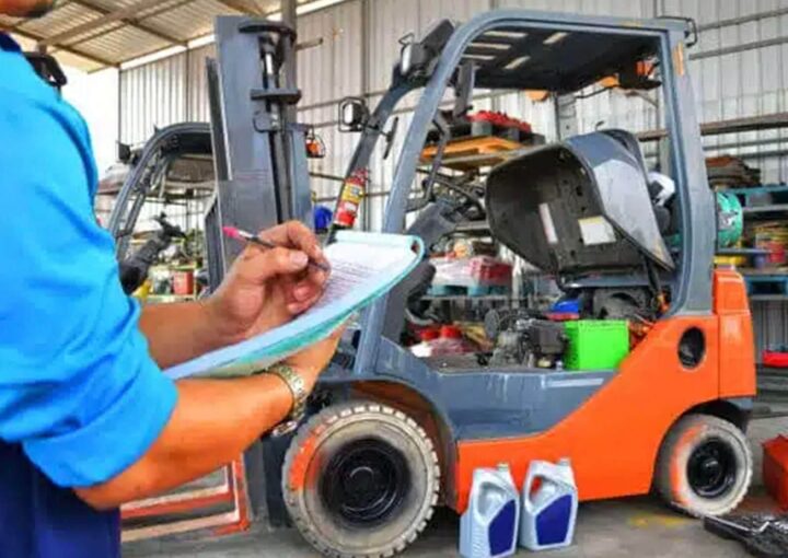 A technician inspecting a forklift in a warehouse with a checklist and maintenance supplies.