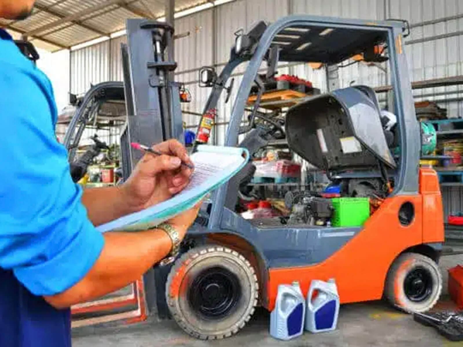 A technician inspecting a forklift in a warehouse with a checklist and maintenance supplies.